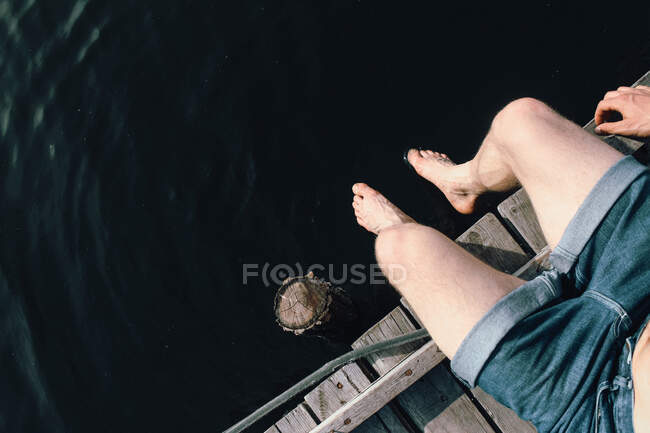 Ноги парня возле маленького озера на Украине — стоковое фото