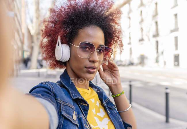 Selfie de mujer con pelo afro con sus auriculares - foto de stock