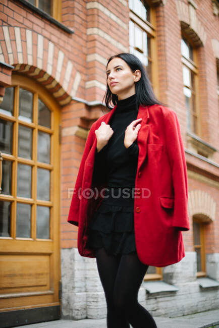 Mujer de moda de estilo joven en chaqueta roja en la ciudad - foto de stock
