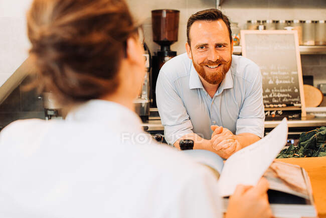 Restaurant lifestyle. Male chef smiling at client — Stock Photo