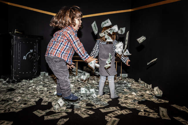 Kleine Mädchen haben zusammen Spaß, während sie Geldscheine in die Luft werfen — Stockfoto