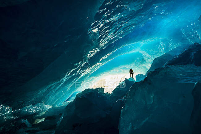 Montañista explorando enorme cueva de hielo en el Parque Nacional Banff - foto de stock