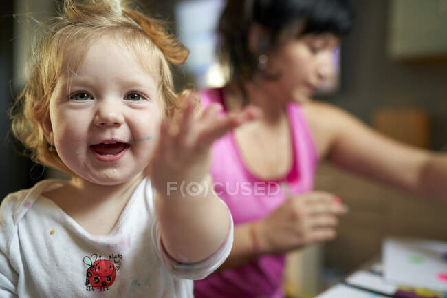 Glücklich lächelnd zeigt süßes kleines Mädchen in die Kamera — Stockfoto