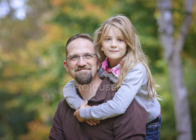 Padre con hija rubia joven abrazándose. - foto de stock