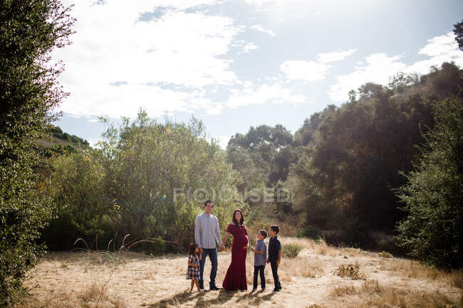 Famille heureuse posant à l'extérieur dans le parc — Photo de stock