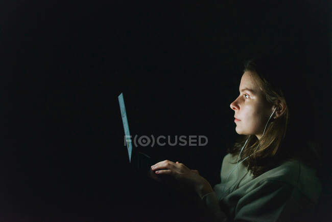 Mujer trabajando en el ordenador portátil por la noche - foto de stock
