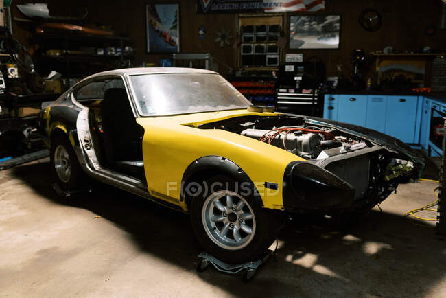Vecchia auto d'epoca su rulli ottenere il motore ricostruito in garage in luce — Foto stock