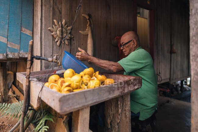 Стокова картина літніх чоловіків, що роблять апельсиновий сік — стокове фото
