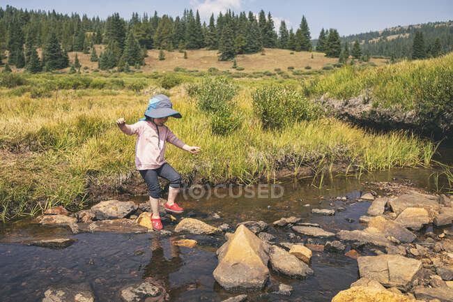 Молодая девушка, пересекающая реку в Дикой природе, Колорадо — стоковое фото
