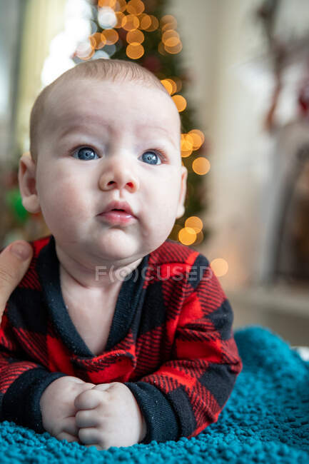 Wide eyed baby boy crawling near Christmas tree. — Stock Photo