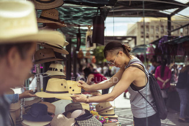 Alternative fit traveller buys hat at Mexican market place — Stock Photo