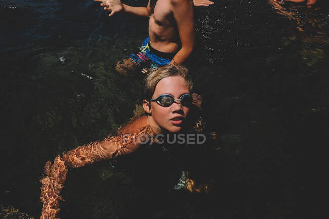 Junge mit Brille blickt von einem kalifornischen Schwimmloch auf. — Stockfoto