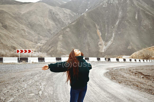Woman having fun on the mountain road — Stock Photo