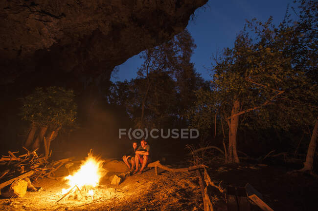 Mature couple enjoying camp fire in Laos — Stock Photo