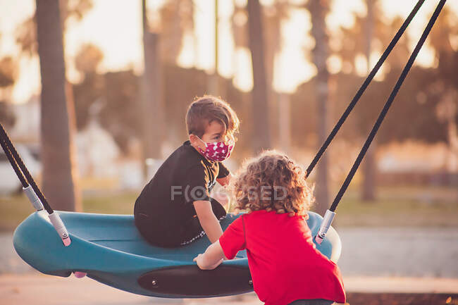 Boy wearing a mask playing at a playground — Stock Photo