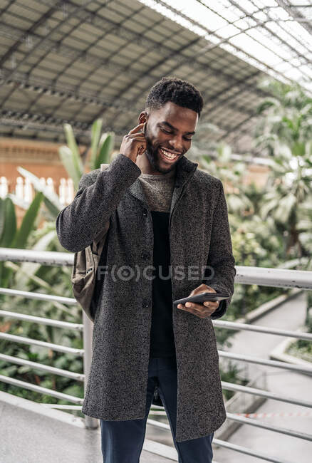 Empresario afro en la ciudad hablando por teléfono - foto de stock