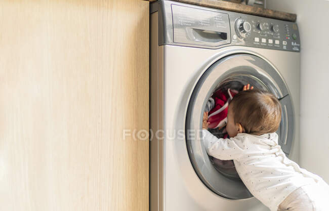 Bambina guardando la lavatrice — Foto stock