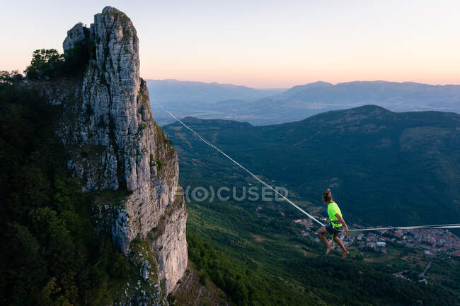 Slackliner sitting in the void waiting to walk the line — Stock Photo