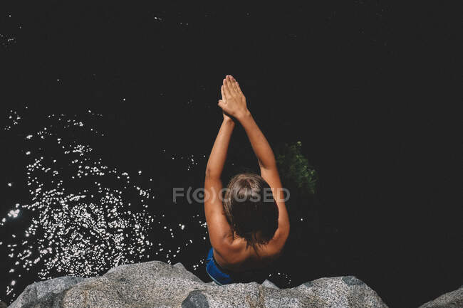 Tan Skinned Boy Prepares for Cliff Dive with Hands Together in a V — Stock Photo