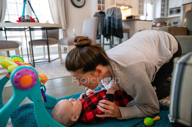 Mother playing with baby in the living room. — Stock Photo