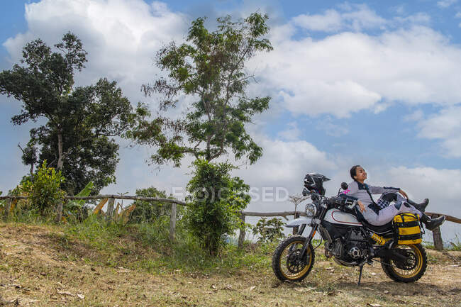 Молодая женщина на мотоцикле сидит — стоковое фото