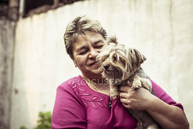 Messicano donna abbraccia carino cane su locale messicano strada in estate — Foto stock