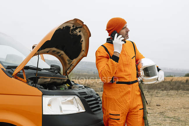 Man dressed as astronaut using smart phone — Stock Photo