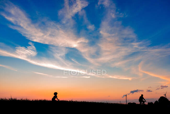 Отец и сын катаются на велосипедах вместе на закате — стоковое фото