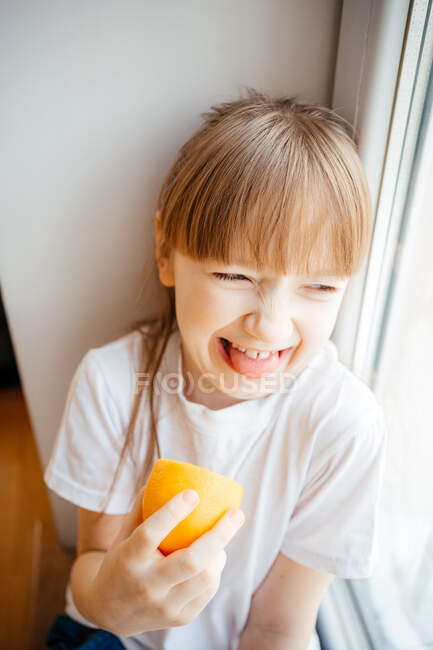 Reacción de la chica a la degustación de limón fresco - foto de stock
