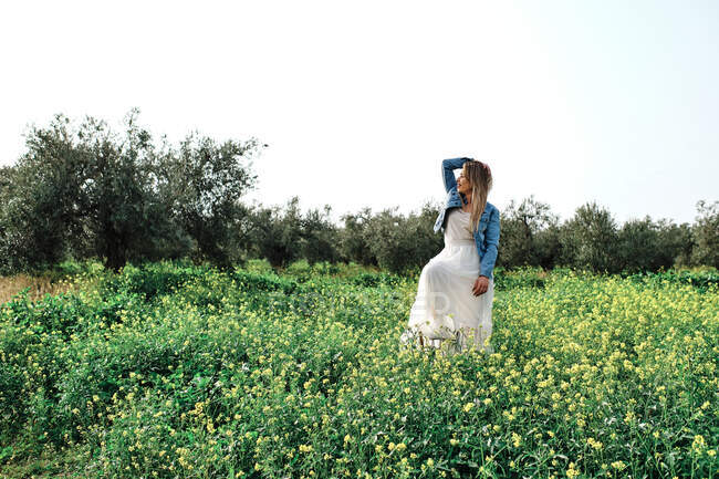 Молода дівчина в сукні позує в полі — стокове фото