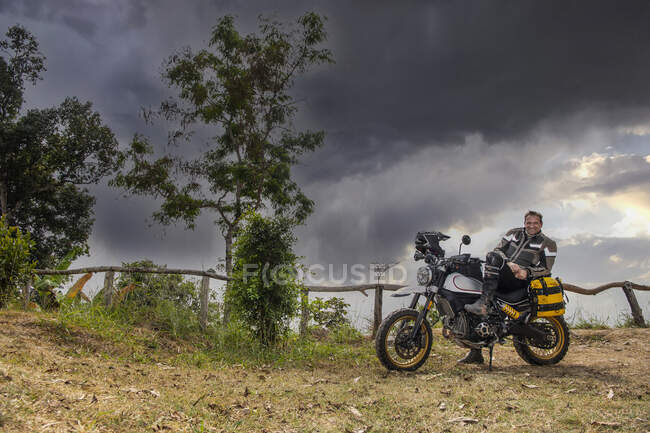 Young man on mototcycle in road — Stock Photo
