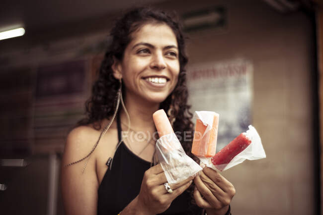 Attrayant sourire jeune femme mexicaine alternative avec des crèmes glacées — Photo de stock