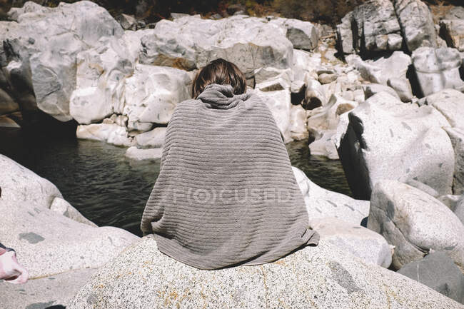 Figure Cloaked in a towel Looks like the surrounding Rock. — Stock Photo