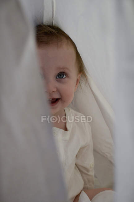 Bebé niña escondido detrás de hoja - foto de stock