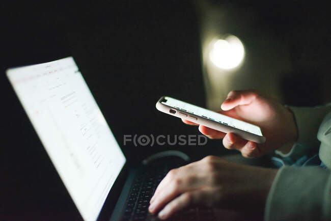 Anonymous woman working on laptop at night — Stock Photo