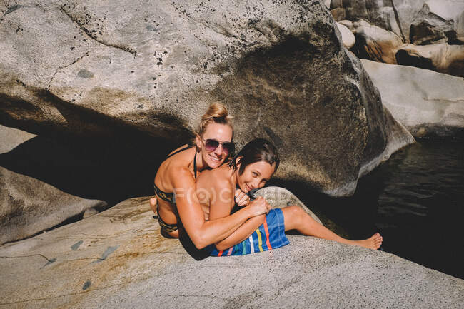 Madre abbracci imbarazzato tween figlio su un estate giorno — Foto stock