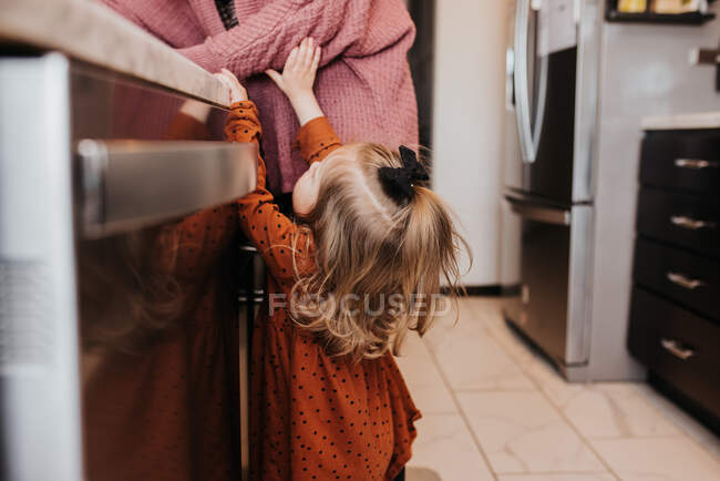 Beautiful young mother and her daughter on kitchen — Stock Photo