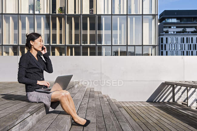 Mujer de negocios asiática en Paris con laptop - foto de stock