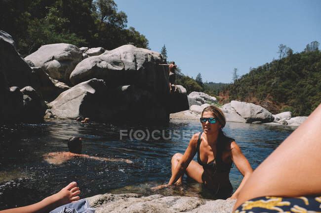 Amigos nadando y jugando juntos en el calor del verano de California - foto de stock