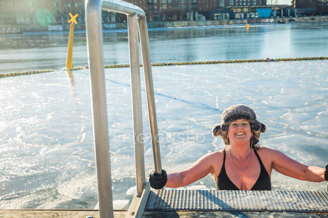 Femme américaine portant un chapeau de fourrure descendant des escaliers dans l'eau glacée Danemark — Photo de stock
