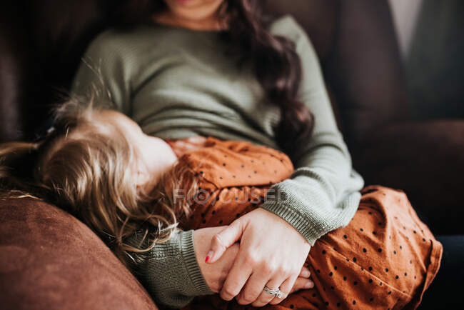 Bela jovem mãe e sua filha na poltrona — Fotografia de Stock