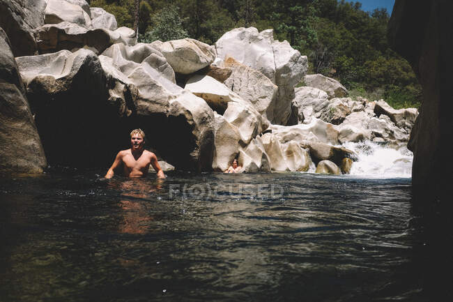 Teen Boys Swimming in the River Canyon Next to a Waterfall — Stock Photo