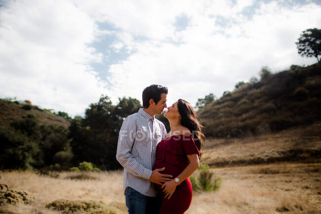 Marito e moglie in attesa in posa sul campo a San Diego — Foto stock