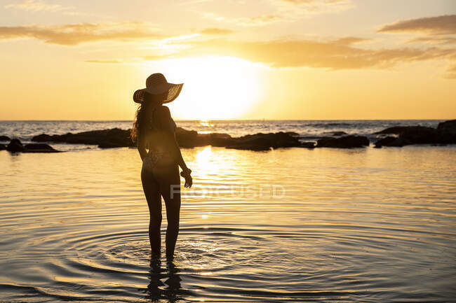 Joven hermosa chica en bikini con el pelo largo y rubio en la playa. - foto de stock
