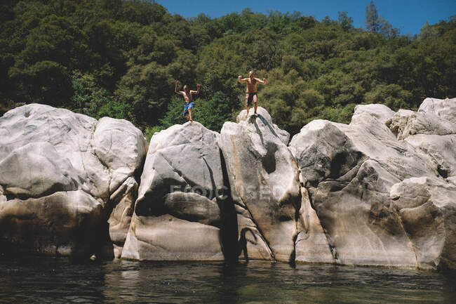 Due ragazzi saltano dai massi al fiume Yuba — Foto stock