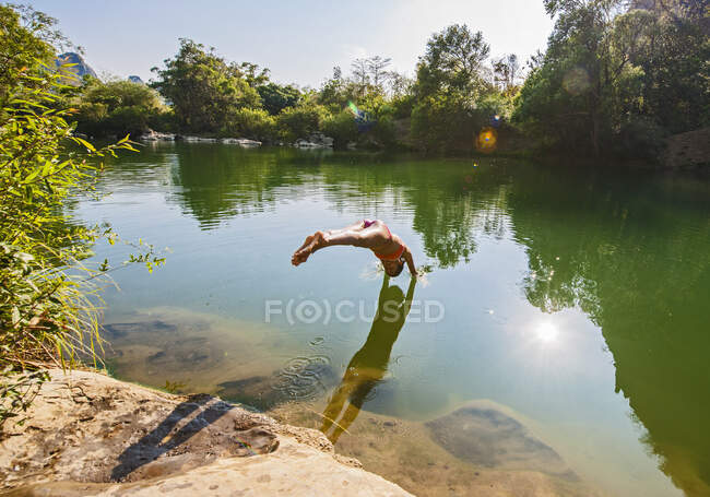 Young woman relaxing by th elake in summer — Stock Photo