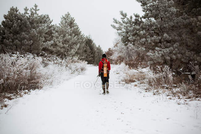 Young man with bow and arrow hunting in Wisconsin winter woods — Stock Photo