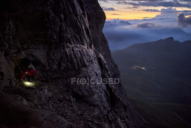 Un uomo che si arrampica sulla parete nord dell'Eiger al tramonto. Regione di Jungfrau, Svizzera — Foto stock