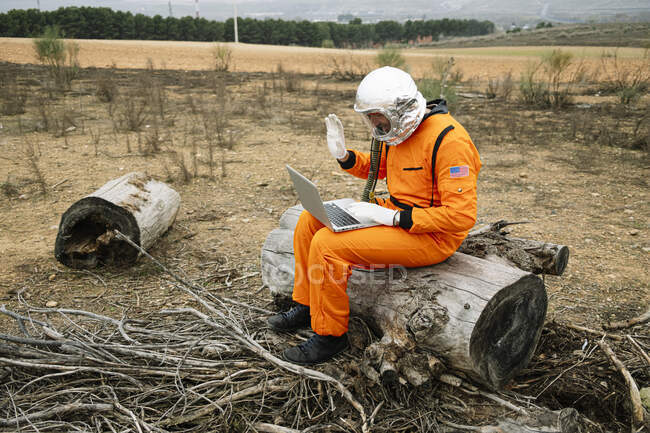 Hombre vestido como astronauta usando laptop - foto de stock