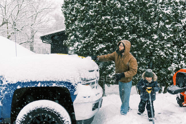 Отец и сын вместе убирают снег на подъездной дорожке в Массачусетсе — стоковое фото